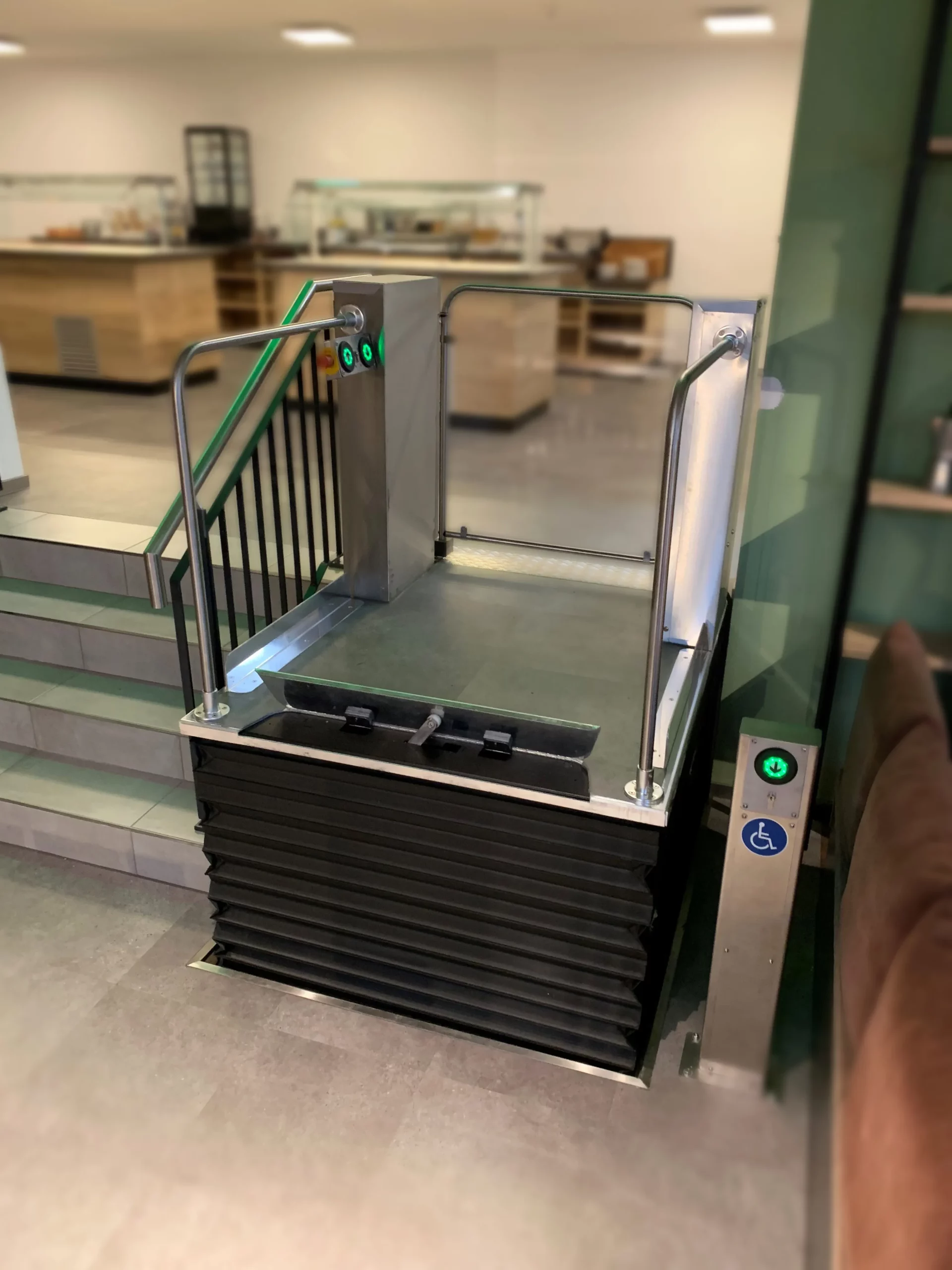 Hublift neben einer Treppe in einem Büro. Schleswig-Holstein Lifte bietet qualitativ hochwertige Hublifte und ehrliche Beratung.